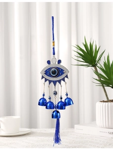 Detailed view of Turkish Evil Eye wind chime with five blue bells and silk tassel
