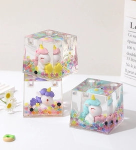 Transparent acrylic unicorn pen holder with colorful crystal beads inside for desk.