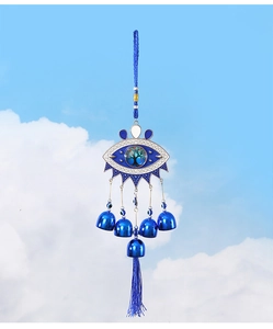 Detail of blue Evil Eye wind chime with Tree of Life design and metallic bells