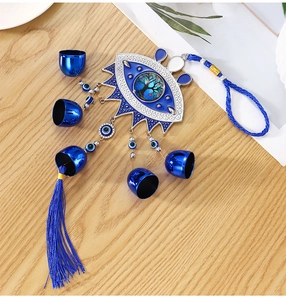 Detail of blue evil eye wind chime with metal bells, tree of life and silk tassels