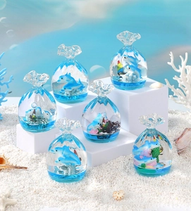 Detail of dolphin miniature glass bags with blue liquid and coral ornaments