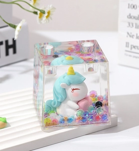 Clear acrylic unicorn pen holder detail showing the box, figurine, and floating beads.
