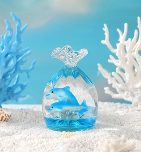 Detail of blue liquid hourglass toy with dolphins and white sand in ocean theme