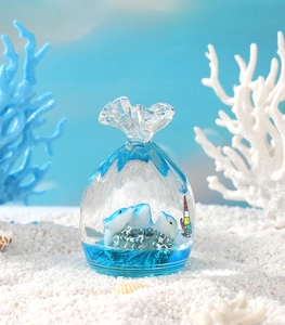 Macro shot of liquid hourglass toy with blue dolphins and coral in transparent pouch design