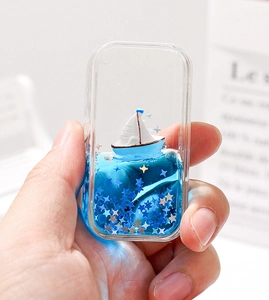 Gros plan d'un voilier flottant dans un ornement de bureau liquide bleu mouvant