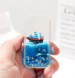 Détail d'un aimant de réfrigérateur créatif en acrylique bleu avec bateau et étoiles