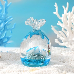 Ocean themed glass liquid hourglass with white dolphins and blue sea waves decor