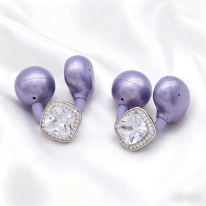 Elegant purple wireless earbuds with square crystal rhinestones on white silk background