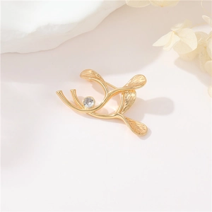 Golden ginkgo leaf brooch with zircon stone and branch design on elegant background