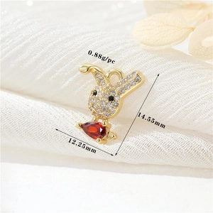 Macro d'un pendentif lapin en or 14k avec zircons blancs et pierre rouge en goutte d'eau
