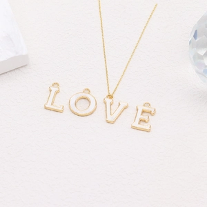 Detailed view of 14k gold chain with LOVE letter charms and white enamel finish