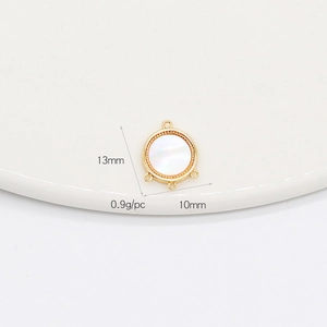 Vue macro du pendentif de bijoux en coquille dorée mesurant 13mm x 10mm et pesant 0,9 gramme