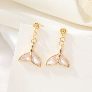 Detail view of 14K gold fishtail earrings with inlaid mother of pearl and zircon accents