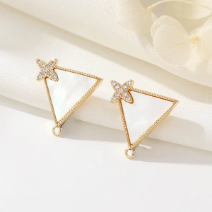 Macro view of triangle shell pendants in 14K gold with star zircon inlay details