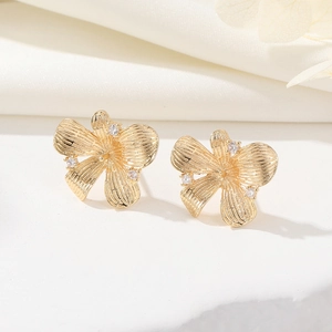 Dettaglio di orecchini a fiore placcati in oro 14K con accenti in micro-intarsio di zirconi