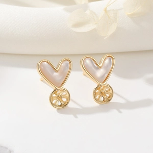 Macro detail of 14K gold plated heart ear stud base with white mother of pearl inlay