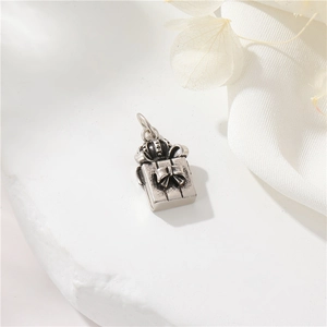 Macro view of vintage 14K gold filled gift box pendant with crown and bow details