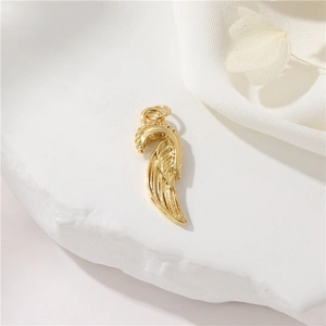 Detailed macro shot of a golden 14K gold-filled angel wing pendant with feather texture