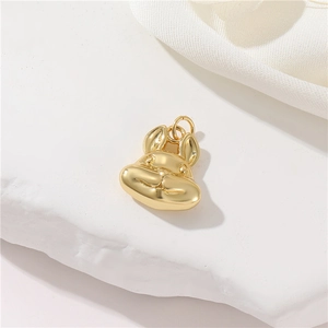 Detailed macro view of a 14K gold plated rabbit charm pendant on natural white rock