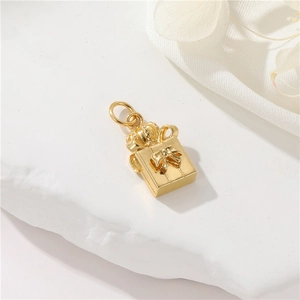 Macro detail of 14K gold-filled gift box pendant with crown and ribbon bow design