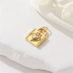 Macro shot of 14K gold crown heart padlock pendant on stone base with satin background