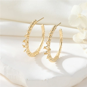 Detalle de pendientes de aro bañados en oro 14K con agujas de plata S925 y textura de perla