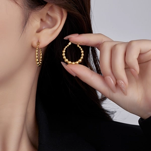 Orecchini a cerchio dorati con perle di metallo lucido in uno stile minimalista ed elegante