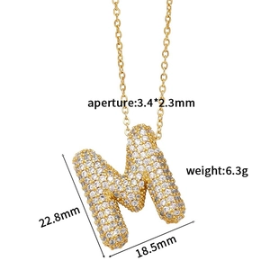 Detailed view of gold-tone letter M pendant with zircon pave and size measurements