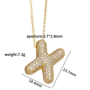 Macro view of gold plated 'X' letter pendant with detailed zircon measurements and size