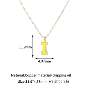 Detalle del colgante letra I de cobre bañado en oro de 14K con acabado de esmalte amarillo