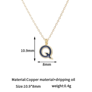 Detalle del colgante letra Q bañada en oro de 14K con esmalte de color azul oscuro