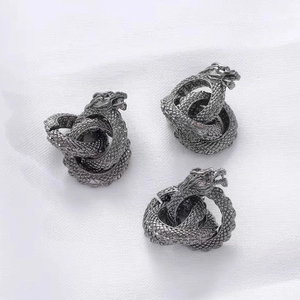 Three pieces of vintage dragon-themed metal charms with intricate scale textures