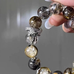 Handcrafted grey crystal bead bracelet with silver dragon charm and natural textures