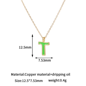 Detalle del colgante letra T de cobre chapado en oro de 14K con esmalte verde brillante
