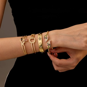 Quattro bracciali placcati oro 14K con zirconi, motivi luna, cuore e occhio