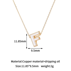 Detail view of 14K gold plated letter F pendant with white enamel dripping oil inlay