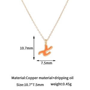 Detalle de colgante de letra bañada en oro 14K con esmalte y sus dimensiones