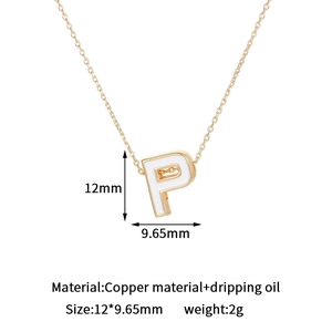 Detailed view of 14K gold plated letter P pendant with white enamel drip and copper base
