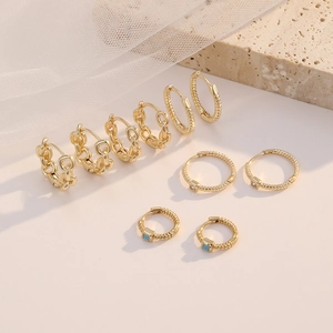 Luxurious 14K gold plated chain hoop earrings set with zircon stones on stone background