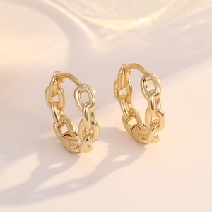 Detail of 14K gold chain link hoop earrings showing high-shine polished metallic texture