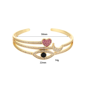 Dettaglio del bracciale dorato multistrato con ciondoli a cuore rosa e malocchio