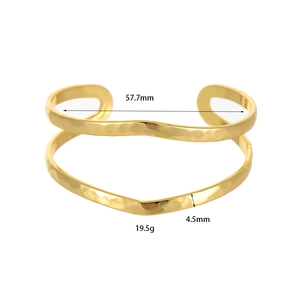 Dettaglio di un bracciale a fascia aperta martellato oro con trama a onde e misure