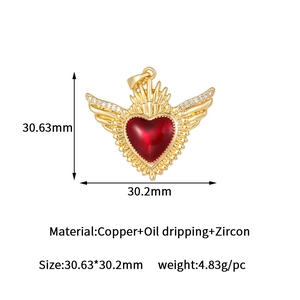 Dettaglio del ciondolo a cuore placcato oro con goccia d'olio rosso e ali in zircone