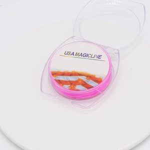 Macro view of bright pink elastic crystal cord roll in round transparent packaging