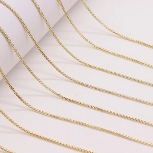 Polished gold plated box chains for necklaces shown in a minimalist parallel layout