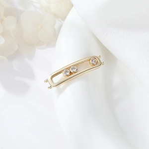 Macro detail of gold plated geometric double ring connector with sliding zircon stones