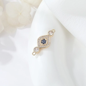 Macro shot of gold-plated Evil Eye connector with blue and white cubic zirconia