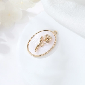 Dettaglio macro del ciondolo ovale in madreperla bianca con una rosa placcata oro 14K