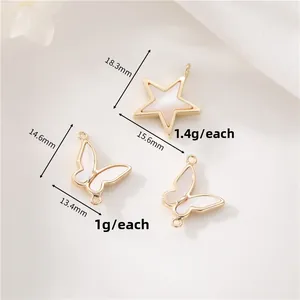 Macro detail of gold star and butterfly charms with mother of pearl inlay and dimensions