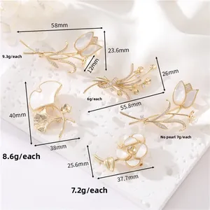 Détail de cinq broches botaniques dorées avec des textures de tulipes et de nacre